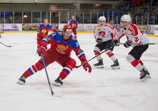 Switzerland defenceman Nico Gross (16)  checks Russia