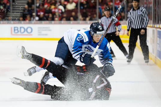 Eeli Tolvanen of Finland tackles Nicholas Suzuki of Canada