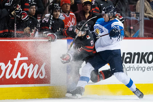 Cody Glass of Canada is being tackled by Eeli Tolvanen of