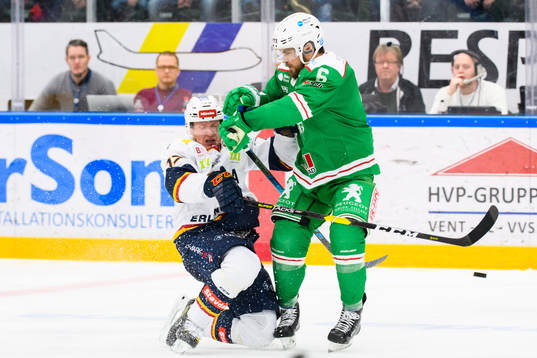 Rögles Craig Schira tacklar Djurgårdens Henrik Eriksson