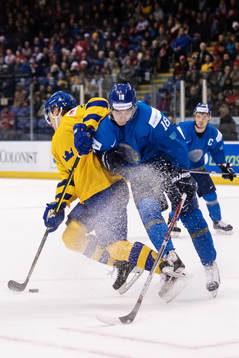 Adam Boqvist of Sweden is being tackled by Batyrlan Muratov