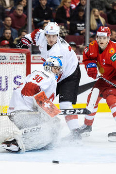 Goaltender Luca Hollenstein and Nico Gross of Switzerland