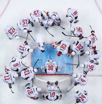 Players of Switzerland are gathered around goaltender Luca