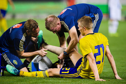 Jonathan Augustinsson of Sweden receives help
