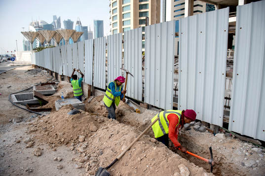 Workers digging a ditch in central Doha, Qatar, where the