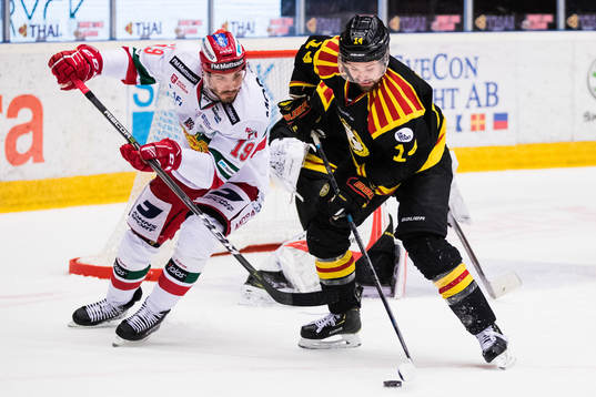 Moras John Persson i kamp om pucken med Brynäs Johan Alcén