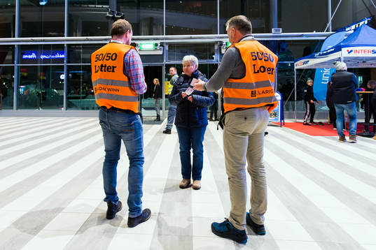 Två försäljare av 50/50-lotter innan ishockeymatchen i