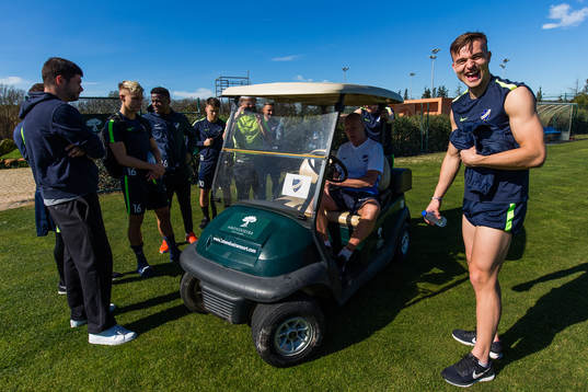 Spelarna samlas runt en golfbil