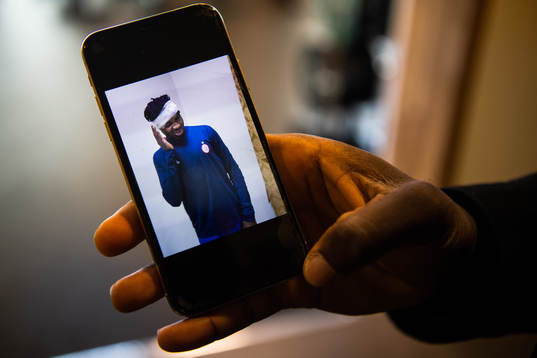 Häckens Kwame Kizito visar upp telefonen med en bild på