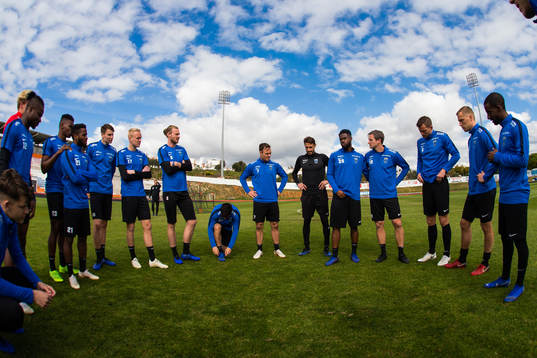 Spelare och ledare samlas innan en fotbollsträning med