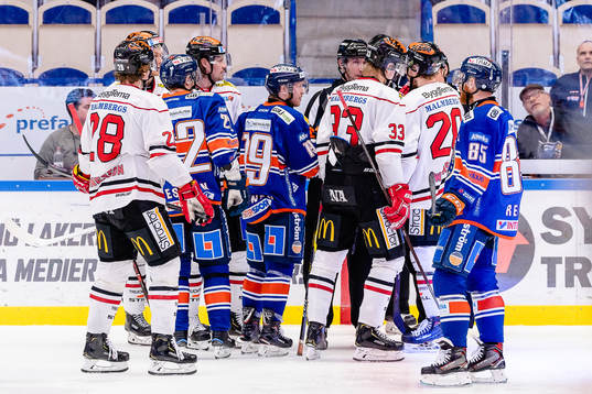 Spelare från båda lagen diskuterar med domarna