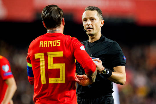 Referee Andris Treimanis talks to Sergio Ramos of Spain