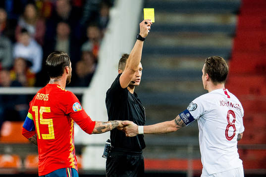 Sergio Ramos of Spain, referee Andris Treimanis and Stefan