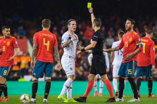 Stefan Johansen of Norway receives a yellow card
