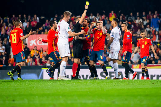 Inigo Martinez Berridi of Spain is shown a yellow card by