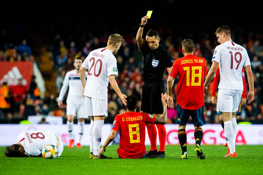Dani Ceballos Fernandez of Spain is shown a yellow card by