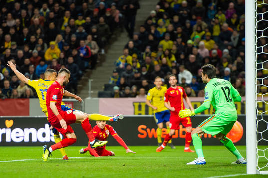 Robin Quaison of Sweden scores 1-0 behind goalkeeper