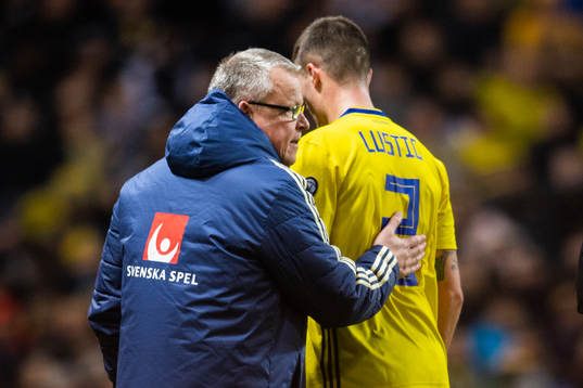 Head coach Janne Andersson tends to Mikael Lustig of Sweden
