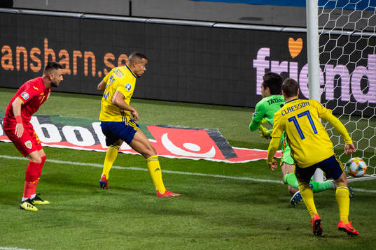 Robin Quaison of Sweden scores 1-0 behind goalkeeper