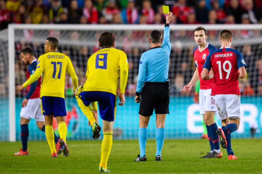 Ole Kristian Selnæs of Norway is shown a yellow card