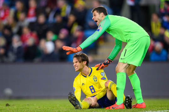 Albin Ekdal of Sweden in pain and goalkeeper Rune Almenning