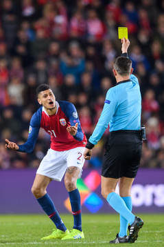 Bjørn Maars Johnsen of Norway is shown a yellow card