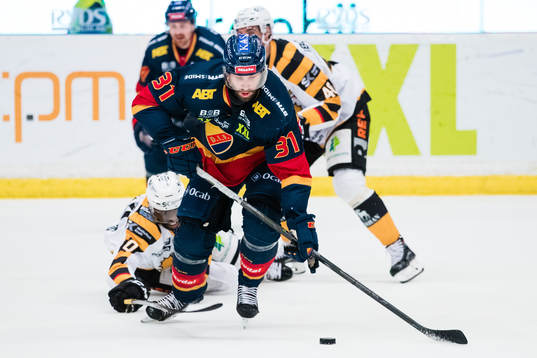 Djurgårdens Dick Axelsson  i kamp om pucken Skellefteås