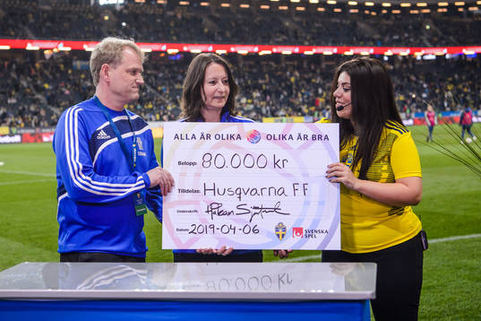 Representatives from Husqvarna FF receives a check from the
