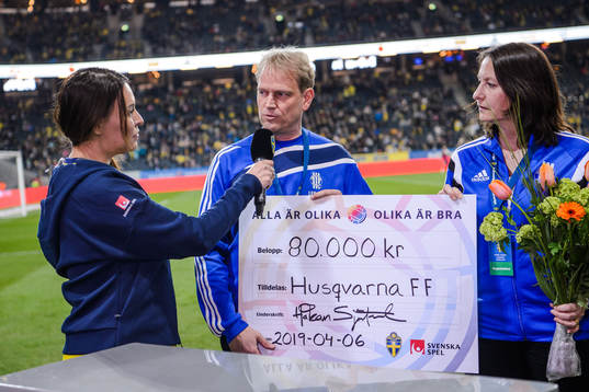 Representatives from Husqvarna FF receives a check from the