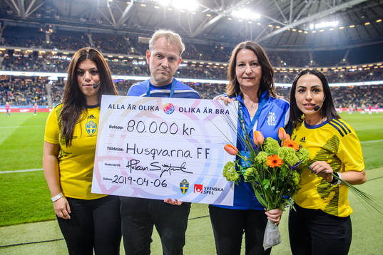 Representatives from Husqvarna FF receives a check from the