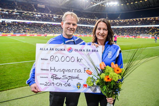 Representatives from Husqvarna FF receives a check from the