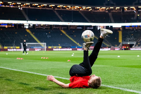 A kid performs football tricks