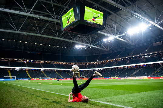 A kid performs football tricks