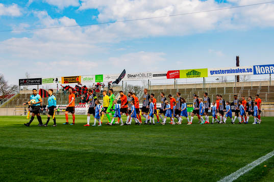Spelarna gör entre till fotbollsmatchen i Division 1