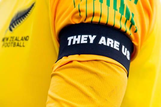 A black armband with the text "They are us"