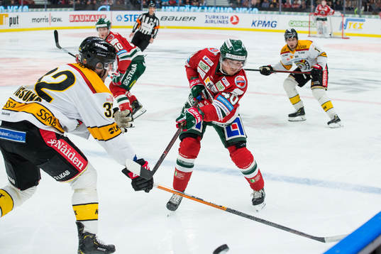 Frölundas Joel Mustonen skickar in en puck i fotobåset