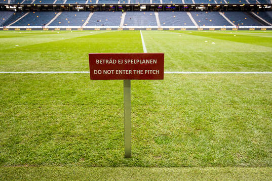 En skylt visar förbud mot att beträda spelplanen
