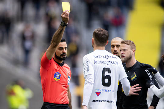 s Panajotis Dimitriadis får gult kort av domare Mohammed
