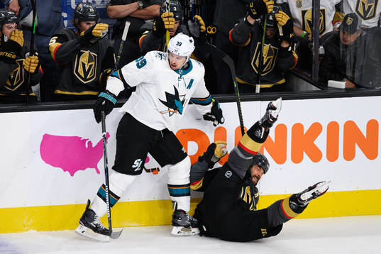 Logan Couture of San Jose Sharks tackles Deryk Engelland of