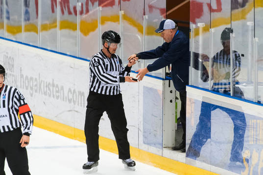 Stefan Åsander delivers a new cold puck to the referee