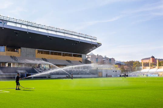 Vattning av fotbollsplanen innan fotbollsmatchen i