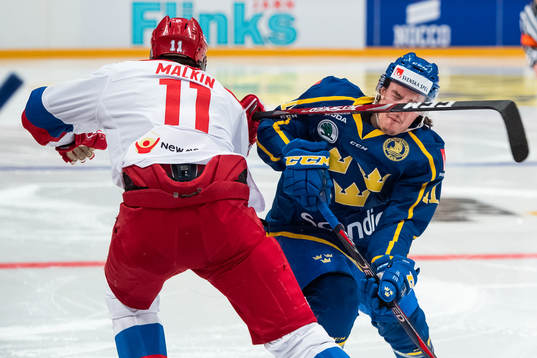 The club of Yevgeni Malkin of Russia hits Joakim Nygård of