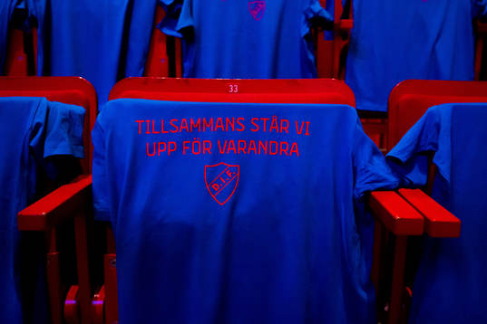 En tröja på en stol med texten Tillsammans står vi upp