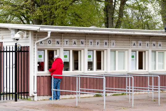 En man köper biljett före fotbollsmatchen i Superettan