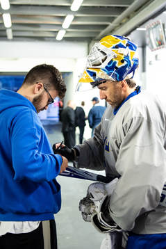 Goaltender Henrik Lundqvist of Sweden and a fan