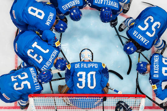 Italian players gather around goaltender Marco de Filippo