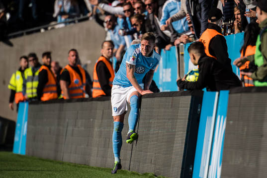 Malmö FFs Sören Rieks på väg över reklamskylt