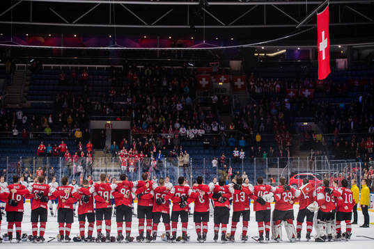 Players of Switzerland sees the Swiss flag being hoisted