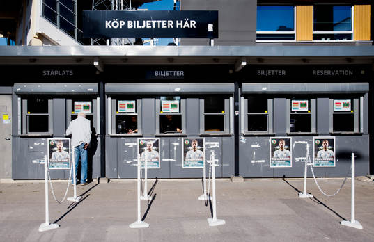 En person köper biljetter i biljettkassan