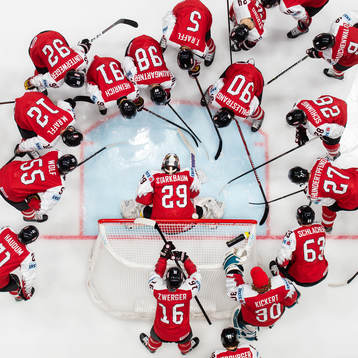 Players of Austria gather around goaltender Bernhard